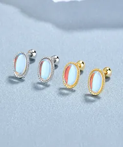 Detailed view of silver and gold moonstone stud earrings with secure screw-back closures