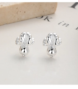 Macro shot of 925 sterling silver ginkgo leaf stud earrings with polished metallic finish