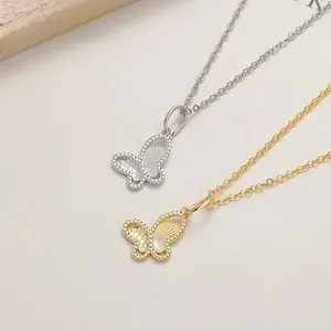 Détail de pendentifs papillons argentés et dorés avec bords perlés et lignes évidées