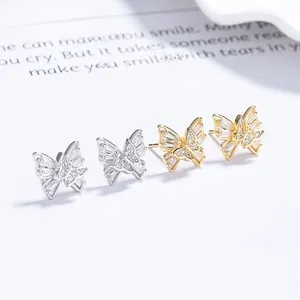 Gros plan sur des boucles d'oreilles papillon en argent 925, finitions or et argent