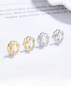Detailaufnahme von Kamelien-Perlenohrringen mit Zirkonia in Gold- und Silberoptik