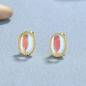 925 silver oval moonstone stud earrings with gold beaded edges on natural stone