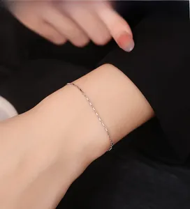 Macro detail of a minimalist 925 silver box chain bracelet worn on a female wrist