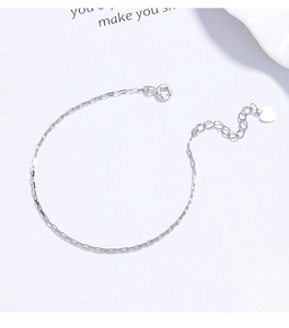Detailed view of silver box chain bracelet with heart charm and lobster clasp closure