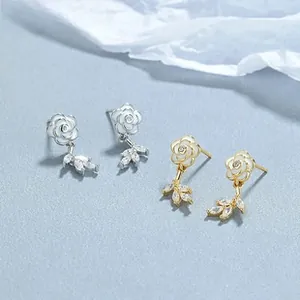 Detailed close-up of camellia flower tassel earrings with zircons in silver and gold