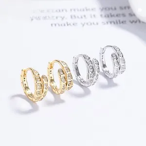 Nahaufnahme von Gold- und Silberschlangenohrringen mit Pavé-Diamantbesatz