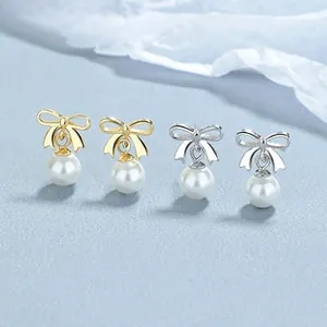 Detail of 925 sterling silver butterfly earrings with elegant white pearl drops