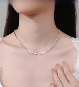 Detailed view of polished silver snake chain necklace on model for delicate style