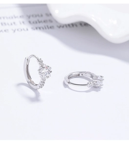 Macro shot of 925 sterling silver star-shaped hoop earrings with sparkling pave zircon stones