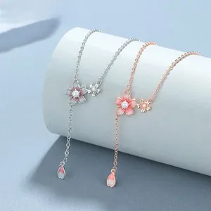 Detailed macro view of pink enamel cherry blossom Y-necklace with small pearls and crystals