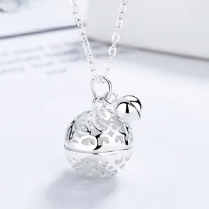 Close-up of S925 silver necklace with hollow filigree ball and small polished bell charm