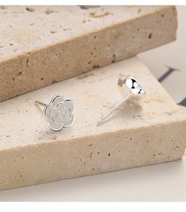 Macro view of 925 sterling silver rose earrings featuring matte petals and polished backs
