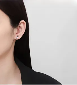Close-up of 925 sterling silver carrot stud earring with opal and green gemstones on model