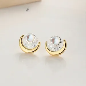 Macro detail of 925 sterling silver astronaut and moon stud earrings with moonstone