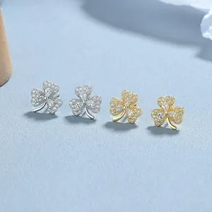 Close-up of 925 silver and gold clover stud earrings with pavé set sparkling zircon stones
