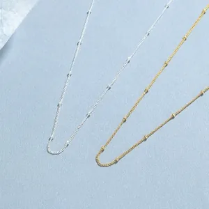 Detail of 925 sterling silver beaded chain necklace in gold and silver finishes