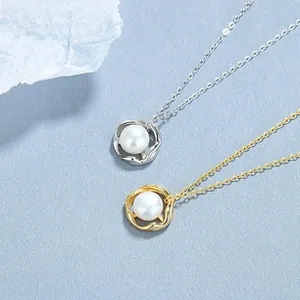 Detail of silver and gold wave-shaped pendants with white pearls on elegant O-chains