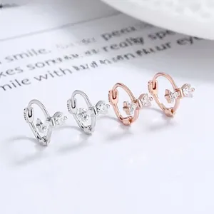 Detailed macro of S925 silver bow earrings with sparkling cubic zirconia inlay
