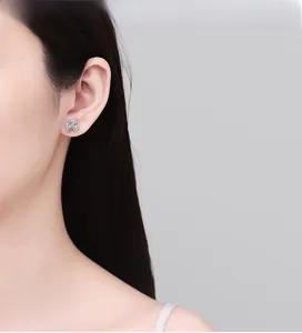 On-ear view of 925 silver clover stud earrings with pavé zircons on female model
