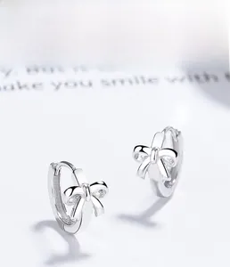 Macro detail of S925 sterling silver bow earrings with a polished metallic mirror finish