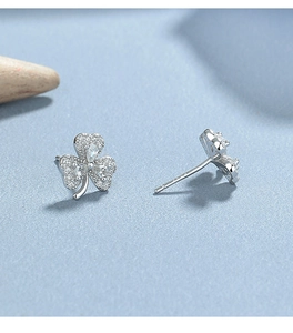 Macro view of silver clover stud earrings featuring pave-set white cubic zirconia stones
