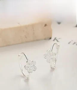 Gros plan détaillé des boucles d'oreilles fleur de pêcher en argent S925 à texture brossée