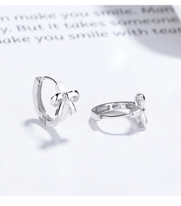 Macro shot of 925 sterling silver bow earrings with polished finish on white background