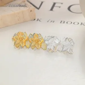 Gros plan détaillé de boucles d'oreilles fleurs en argent et or avec textures métalliques