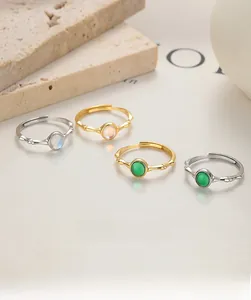 Close-up of bamboo-textured adjustable rings with round moonstone and green gemstones