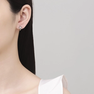 Elegant 925 sterling silver bow hoop earrings worn by a model in a minimalist portrait