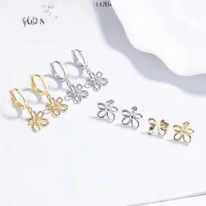 Detail view of 925 silver iris flower earrings in gold and silver set on book