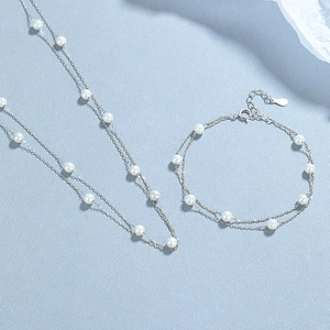 Double layer 925 sterling silver pearl bracelet and necklace set on blue background