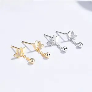 Vue détaillée des boucles d'oreilles papillon en argent et or avec zircons cubiques