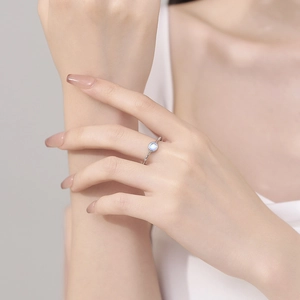 Minimalist 925 sterling silver moonstone ring with blue glow on a female finger