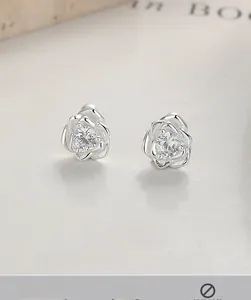 Macro shot of 999 silver rose earrings featuring a sparkling center cubic zirconia