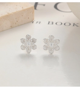 Vue macro des boucles d'oreilles lotus en argent 999 avec texture mate fine