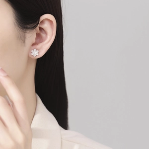 Boucles d'oreilles lotus en argent fin 999 portées sur une oreille féminine