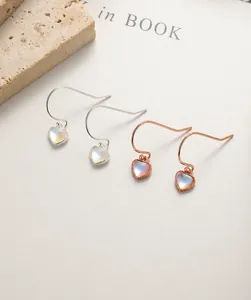 Détail de boucles d'oreilles cœur en pierre de lune en argent 925 et or rose