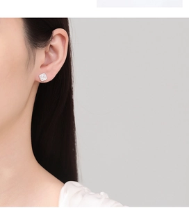 Close-up of square pavé diamond stud earrings in silver on female model's ear