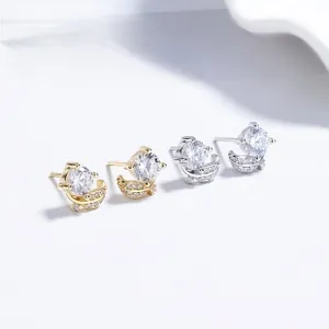Detailed view of silver and gold leaf zircon stud earrings with sparkling round main stones