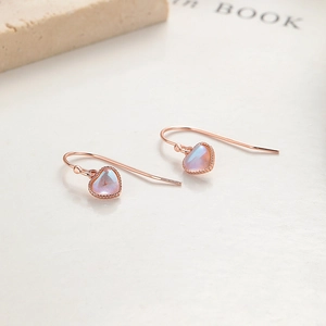 Boucles d'oreilles cœur en opale argent 925 avec finition or rose sur fond minimaliste