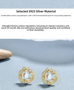 Detail of 925 silver feather stud earrings with moonstone and thick gold plating