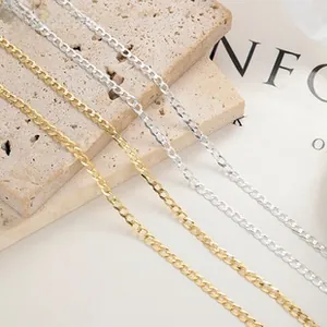 Close-up of interlocking Cuban link chains in gold and silver finish on stone decor