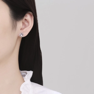 Elegant 925 silver feather stud earrings with moonstone on a female model profile