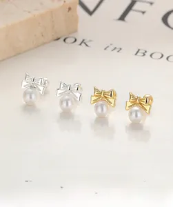 Detailed macro view of S925 sterling silver bow earrings with round white pearls