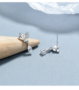 Detail of silver leaf stud earrings with sparkling teardrop zircon on blue background