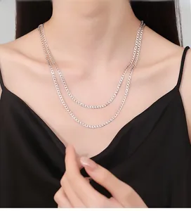 Detail of s925 silver double layer necklace on neck with polished interlocking cuban links