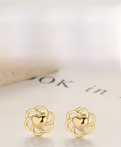 Detailed macro view of S925 sterling silver golden flower stud earrings with heart center
