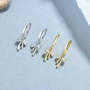 Detailed view of S925 silver bow earrings with drop crystals in gold and silver finishes