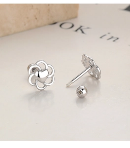 Detailed macro view of 925 silver hollow flower earrings with heart center and screw back